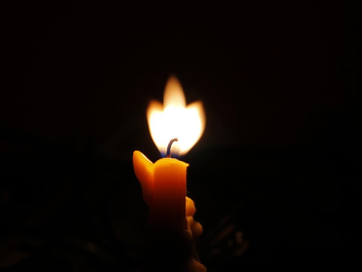 Photo un gros plan d'une bougie allumée dans la chambre noire.