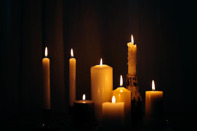 Gros plan de bougies allumées dans une pièce sombre