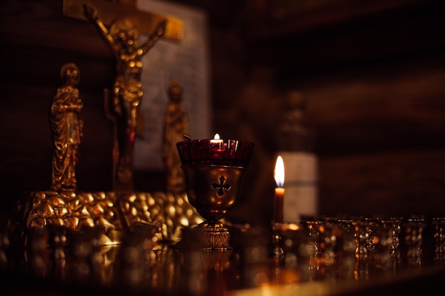 Gros plan de bougies sur un support doré avec des chandeliers sur l'autel devant la crucifixion de Jésus sainte vierge Marie apôtre Jean dans l'église orthodoxe Foi en Dieu religion cérémonie priant le chagrin
