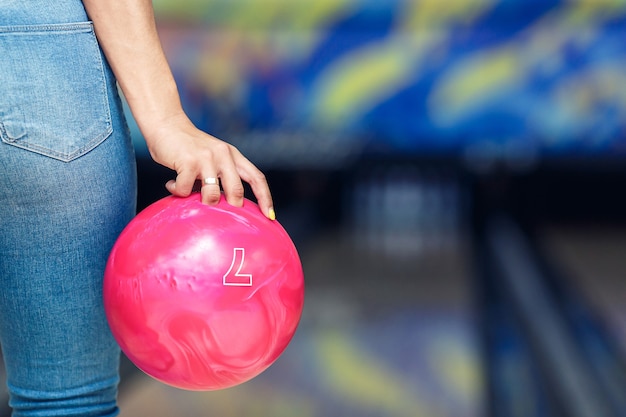 Gros plan d'une boule de bowling dans la main d'une fille.