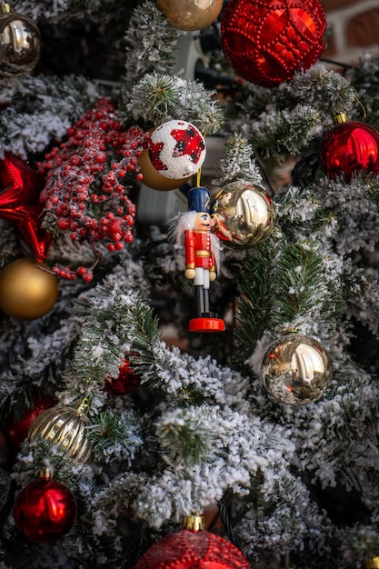 Gros plan de boules dorées et rouges sur l'arbre de Noël. Guirlandes de bokeh en arrière-plan. Notion de nouvel an.