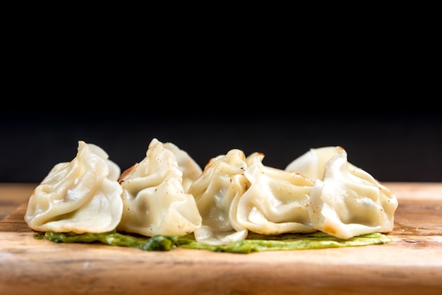 Un gros plan de boulettes chinoises sur un fond noir
