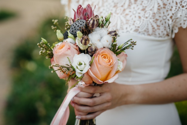 Un gros plan de bouquet de mariage magnifique et sophistiqué tient la mariée dans ses mains. Bouquet de mariage