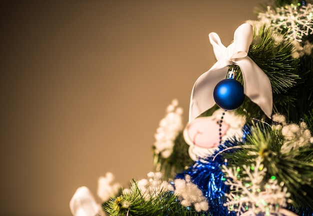 Gros plan sur une branche d'arbre de Noël avec des jouets sur fond sombre. Concept Ambiance Nouvel An et Noël pour le shopping et les remises. Espace publicitaire