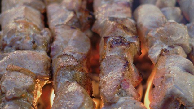 Gros plan de brochettes de porc au barbecue sur des brochettes en métal Griller de la viande de porc pour la fête