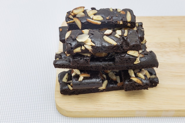 Gros plan des brownies au chocolat gâteau aux noix sur la plaque de bois et fond blanc