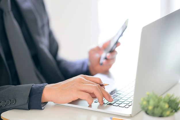 Gros Plan Buisnessman Travaillant Avec Un Ordinateur Portable Et Un Téléphone Mobile.