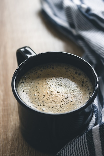 Gros plan sur le café dans une tasse de camping sombre