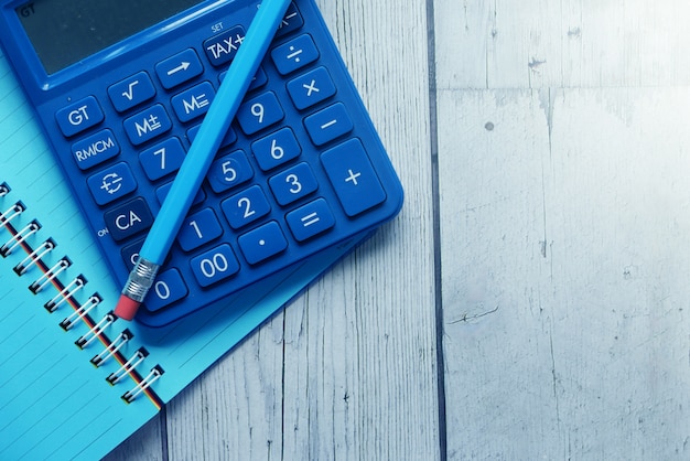 Gros plan de la calculatrice bleue et bloc-notes sur fond de couleur