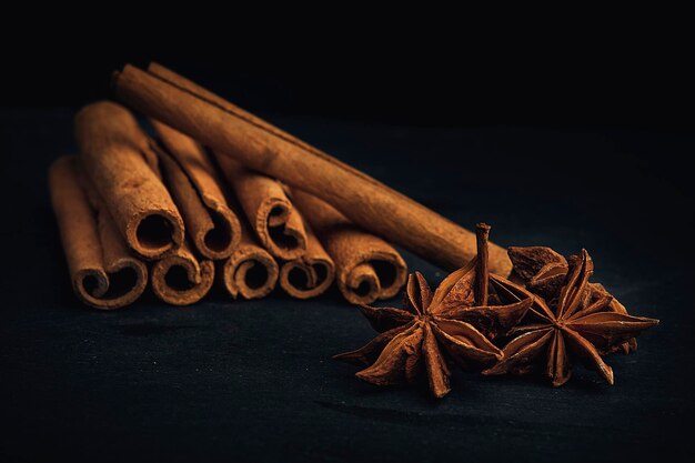 Gros plan d'une cannelle et d'un anis étoilé sur fond noir