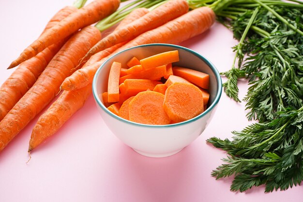 Gros plan sur les carottes avec des feuilles et des tranches de carottes