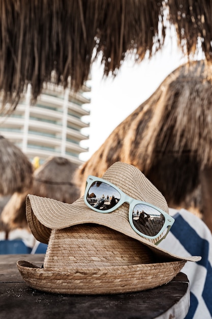 Gros plan de chapeaux de paille d'été sur la table en bois à la plage