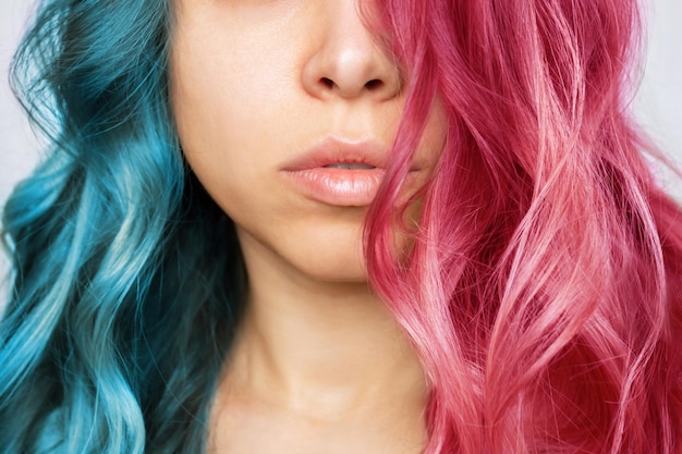 Gros plan des cheveux ondulés mi-roses et mi-bleus d'une jeune femme Résultat de la coloration