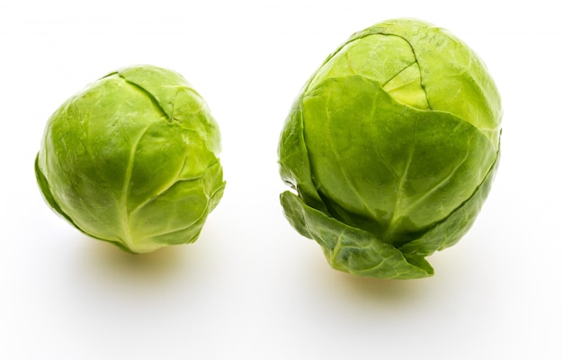 Gros plan de choux de Bruxelles crus, frais et entiers (choux - Brassica oleracea). Isolé sur fond blanc.