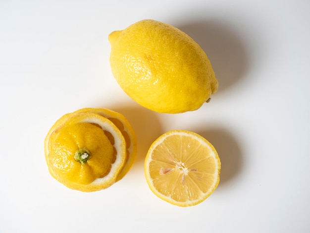 Gros plan d'un citron coupé et entier allongé sur un fond blanc. fruits isolés. Fruit jaune acidulé plein de vitamines. Vue de dessus, mise à plat