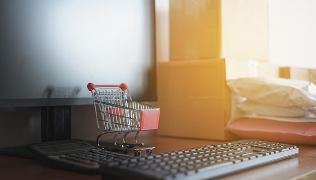 Gros plan sur un clavier d'ordinateur avec une petite calculatrice de panier d'achat et une boîte d'emballage