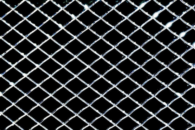 Un gros plan d'une clôture avec un fond noir