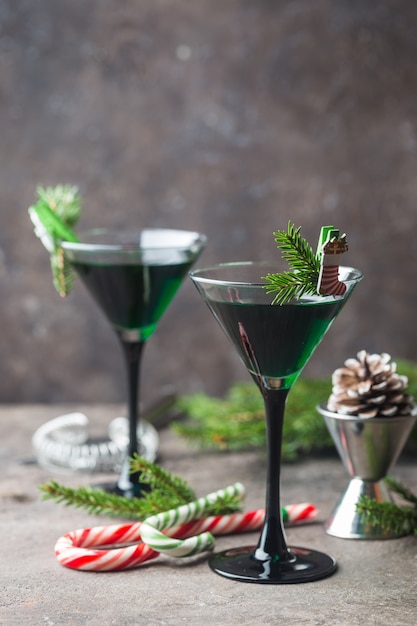 Gros plan de cocktails verts dans des verres à martini avec des feuilles de menthe sur gris