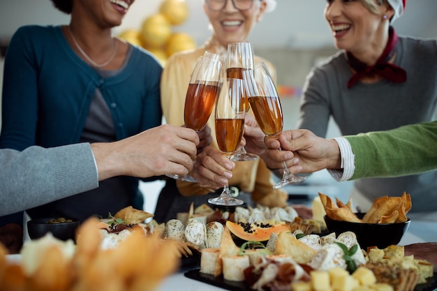 Gros plan sur des collègues de travail portant un toast au champagne lors de la fête du Nouvel An au bureau