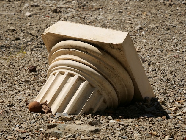 Gros plan d'une colonne grecque cassée sur le sol