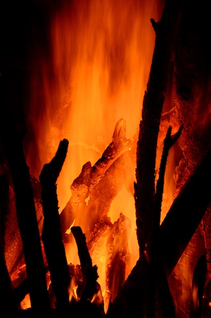 Photo gros plan de la combustion des bûches dans la cheminée sur fond noir