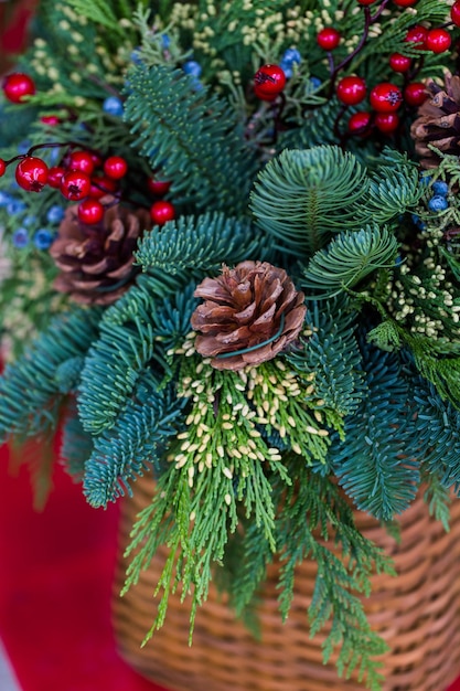 Gros plan sur une couronne de Noël décorée de pommes de pin et de baies.