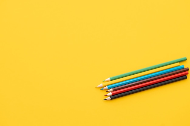 Gros plan crayon de couleur sur fond jaune concept de retour à l'école