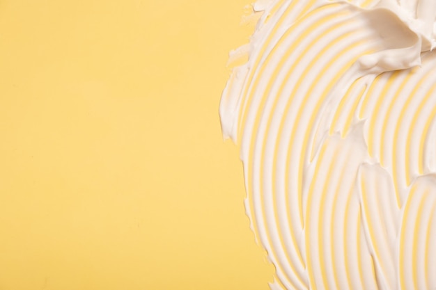 Gros plan crème hydratante frottis tache texture ondulée sur fond coloré avec copie espace produit de beauté soins de la peau
