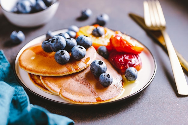 Gros plan de crêpes aux pêches grillées bleuets frais et sirop d'érable