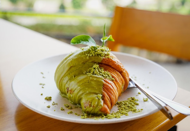 Gros plan croissant au thé vert matcha sur plaque blanche