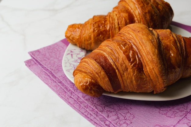 Gros plan de croissants isolés sur fond de marbre.