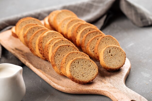 Gros plan sur les croûtons de pain séché sur planche de bois