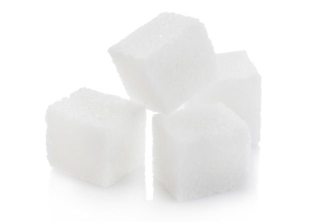 Gros plan de cubes de sucre blanc naturel sur blanc.