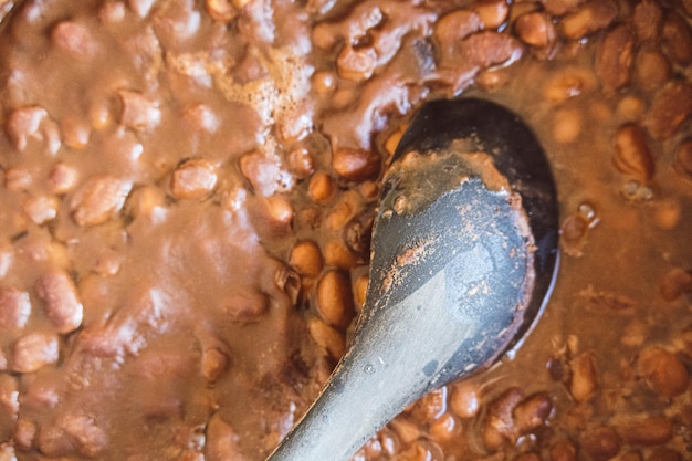 Gros plan d'une cuillère de chocolat chaud avec des haricots dans un bol