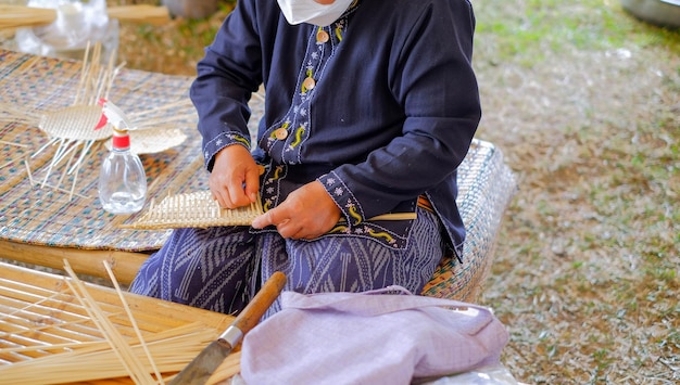 Gros plan et culture Les tribus montagnardes thaïlandaises tissent des paniers de bambou comme souvenirs pour les touristes