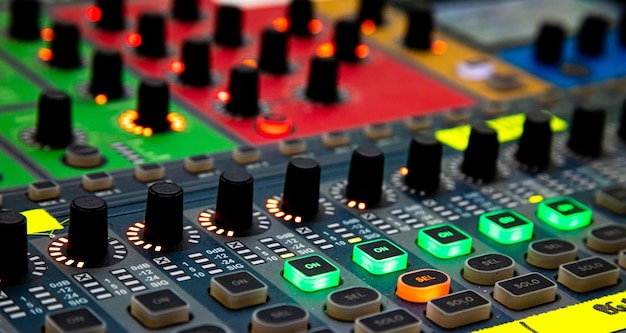 Gros plan des curseurs et des boutons sur la table de mixage audio lors d'un événement en direct