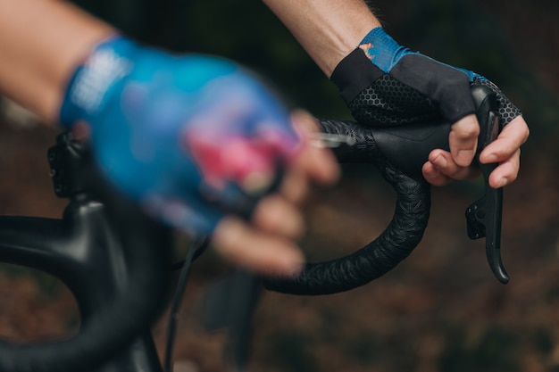 Gros plan sur un cycliste en gants de sport tenant un guidon de vélo