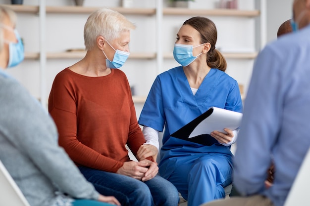 Gros plan d'une dame âgée recevant un soutien psychologique d'une thérapeute