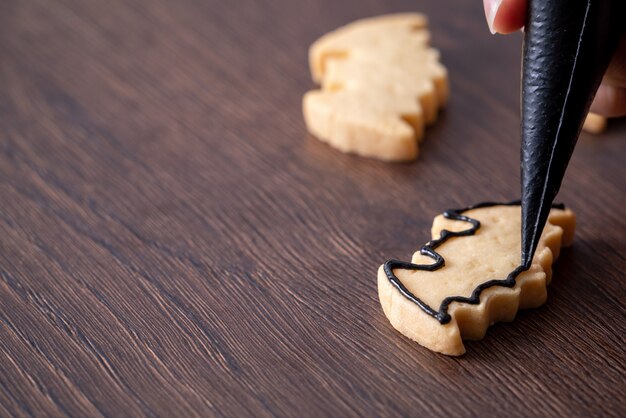 Gros Plan De La Décoration De Mignons Biscuits De Pain D'épice De Chauve-souris Halloween Avec Sac De Garniture De Crème Glacée Glaçage.