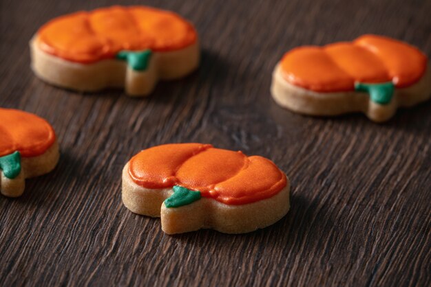 Gros Plan De La Décoration De Mignons Biscuits De Pain D'épice à La Citrouille D'halloween Avec Un Sac De Garniture De Crème Glacée Glaçage.