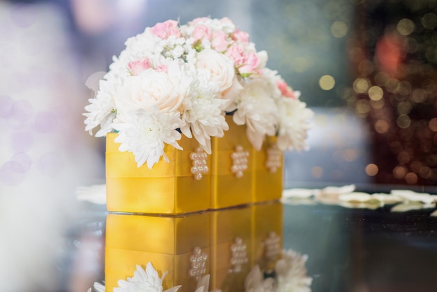 Gros plan d'une décoration de table de mariage avec des fleurs blanches et des pétales.