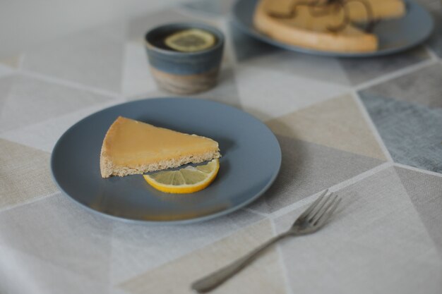 Gros plan d'une délicieuse tarte au citron avec service à thé et citrons