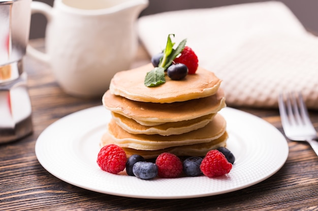 Gros plan de délicieuses crêpes aux myrtilles fraîches et framboises