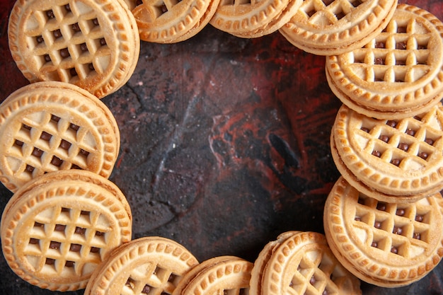 Gros plan de délicieux biscuits au sucre disposés en forme ronde sur fond de couleurs mélangées avec espace libre