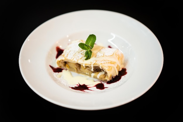 Gros plan d'un délicieux dessert sucré avec une feuille de menthe sur une assiette