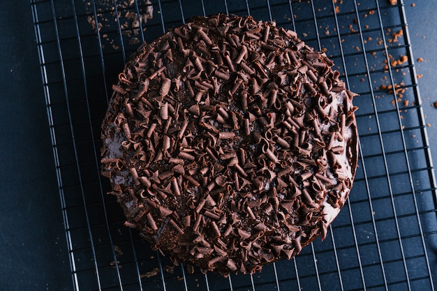 Gros plan d'un délicieux gâteau au chocolat avec des morceaux de chocolat sur une plaque à pâtisserie.