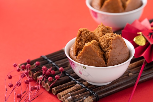 Gros plan d'un délicieux gâteau éponge cuit à la vapeur chinois nommé Fa Gao pour la nourriture traditionnelle du festival du nouvel an lunaire sur fond de tableau rouge.