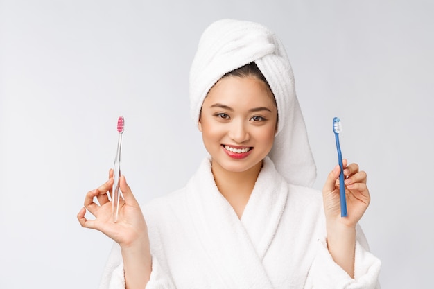 Gros plan des dents de brosse femme sourire. idéal pour le concept de soins dentaires de santé, isolé sur mur blanc. asiatique.