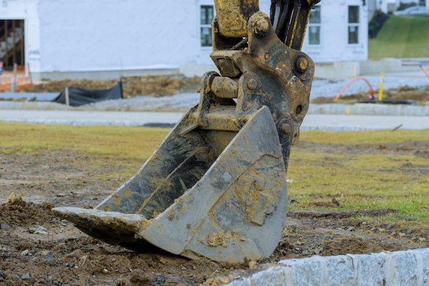 Gros plan des dents de godet sale de l'excavatrice creusant des pièces de machines