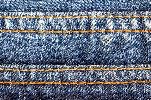Photo gros plan des détails de couture sur les jeans bleus à l'arrière-plan des coutures sur le denim